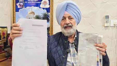 Former Health Minister Balbir Singh Sidhu displays GMADA advertisement and documents related to the enhancement rate of Sectors 76-80 in Mohali. (Express Photo: Jasbir Malhi)