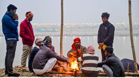 Prayagraj: People sit around a makeshift fire to warm themselves as dense fog blankets the area on a cold winter morning, in Prayagraj, Monday, Dec. 29, 2025. (PTI Photo)