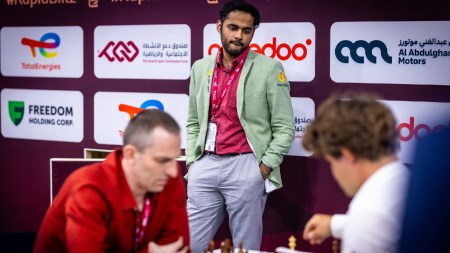 Arjun Erigaisi looks at a game between Magnus Carlsen and Alexander Grischuk during the FIDE World Blitz Championship in Doha on Sunday. (PHOTO: Anna Shtourman via FIDE)