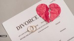 A divorce paper with two engagement rings and a broken paper heart