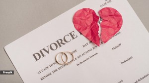 A divorce paper with two engagement rings and a broken paper heart