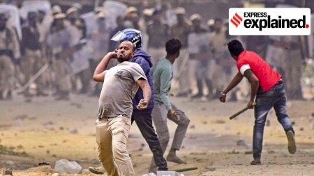 People throw stones during a clash between two groups over the issue of eviction, at Kheroni in West Karbi Anglong district, Assam, Tuesday, Dec. 23, 2025.