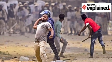 People throw stones during a clash between two groups over the issue of eviction, at Kheroni in West Karbi Anglong district, Assam, Tuesday, Dec. 23, 2025.