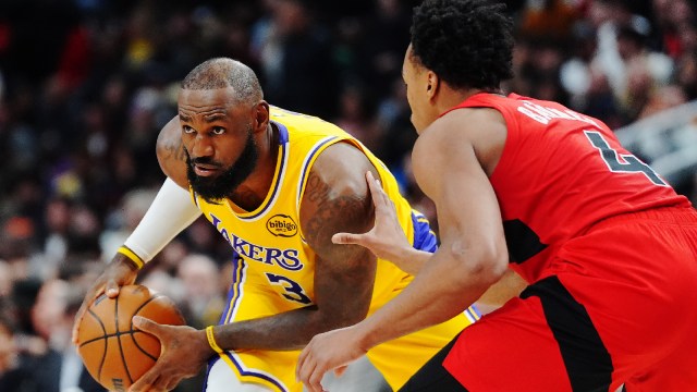 Los Angeles Lakers' LeBron James, left, is guarded by Toronto Raptors' Scottie Barnes (4) during second-half NBA basketball game action in Toronto, Thursday, Dec. 4, 2025. (The Canadian Press via AP)