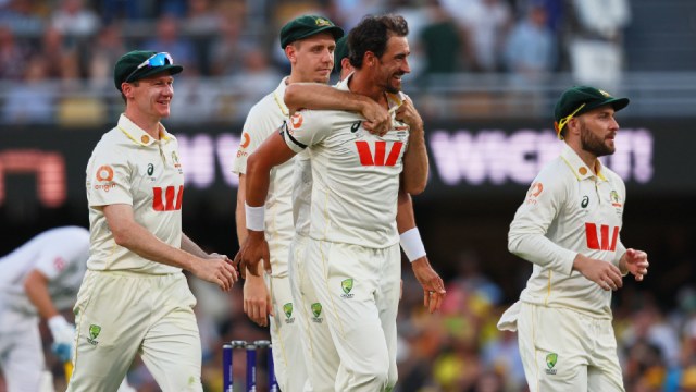 Australia's Mitchell Starc, centre, celebrates with teammate the wicket of during the second Ashes cricket test match between Australia and England in Brisbane, Thursday, Dec. 4, 2025.. (AP Photo)