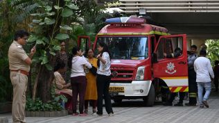 Residents wait outside for a fire on the 14th floor of a residential building to be put out at Andheri West.