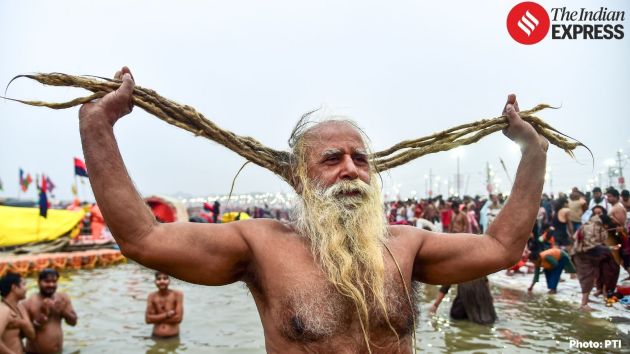 Sadhus and Kalpavasi devotees gather near the Sangam area to perform morning prayers on the first day of Magh Mela