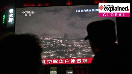 People gather near a large screen at a shopping mall showing CCTV broadcasting a U.S. attack on Venezuela in Beijing, Jan. 4.