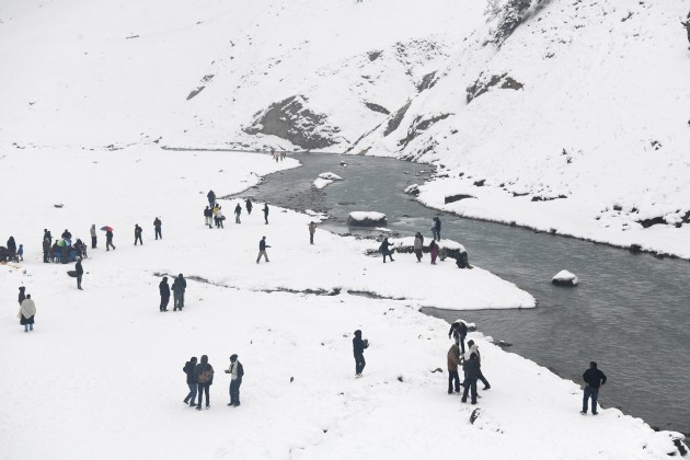 Tourists enjoy a fresh spell of snowfall during their visit to the Kashmir Valley at Sonamarg in Ganderbal on Friday, as popular resorts witnessed snow even though plains of the valley remain snow-free this season. (ANI Photo)