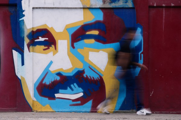 A pedestrian walks past a mural of Venezuelan President Nicolas Maduro Sunday, Jan. 4, 2026. (AP Photo/Matias Delacroix)