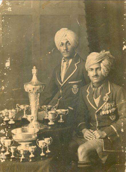 Aitchison alumni Ajit Singh Butalia and Haq Niwaz Tiwana with their sports trophies, 1931. The original of this photo was donated in 2025 by Butalia family to Aitchison Archives.
