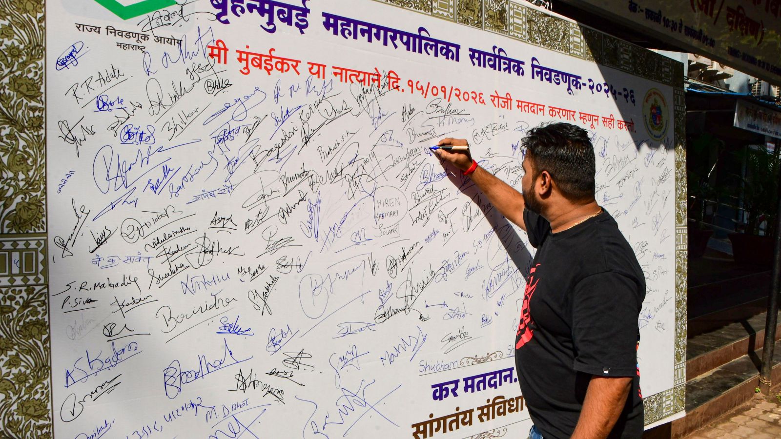 Mumbai: A man signs a board as part of a polling awareness campaign organised at G/South Brihanmumbai Municipal Corporation (BMC) office, ahead of the upcoming civic polls, in Mumbai, Maharashtra, Thursday, Jan. 8, 2026. (PTI Photo) 