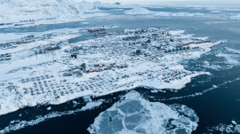 Houses covered by snow are seen on the coast of a sea inlet of Nuuk, Greenland