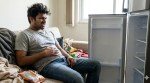 A hangry person sitting in front of an empty fridge