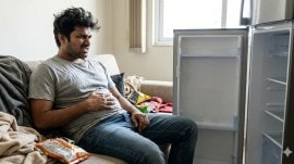 A hangry person sitting in front of an empty fridge