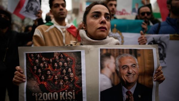 People attend a rally in support of Iran's anti-government protests, in Yalova, Turkey, Friday, Jan. 16, 2026. The placard reads in Turkish: "12.000 people were killed in this genocide". (AP Photo/Emrah Gurel)