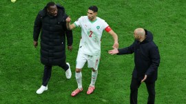 Senegal's head coach Pape Thiaw, left, Morocco's head coach Walid Regragui, right, and Morocco's Achraf Hakimi argue after a controversial penalty was awarded in the AFCON final. (AP Photo)