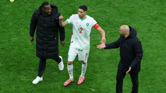 Senegal's head coach Pape Thiaw, left, Morocco's head coach Walid Regragui, right, and Morocco's Achraf Hakimi argue after a controversial penalty was awarded in the AFCON final. (AP Photo)