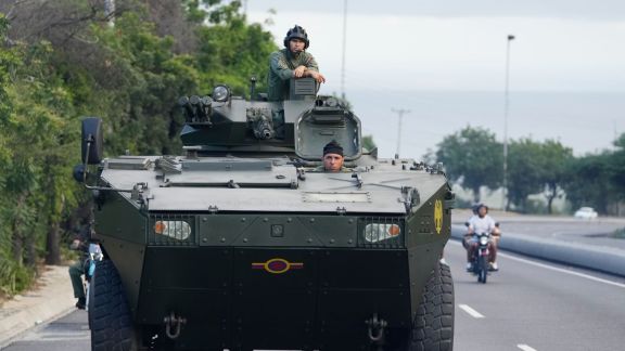 A soldier stands atop an armored vehicle on the highway leading from the international airport toward Caracas, Venezuela, Sunday, Jan. 4, 2026. (AP Photo/Matias Delacroix)