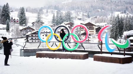 People take photos in front of the Milan Cortina Winter Olympics and Paralympics rings, in Cortina D'Ampezzo, Thursday, Nov. 20, 2025. (AP Photo)