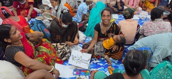 A woman at the CanSupport daycare center holds up a sketch.