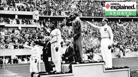 Jesse Owens (centre) salutes the American flag after winning the long jump at the 1936 Summer Olympics.