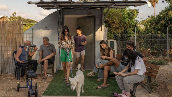 People sit near a bomb shelter between sirens during an Iranian missile attack in Rishpon, Israel, June 24, 2025. The national mood is somewhere between anxiety, resignation and anticipation as President Donald Trump considers whether to attack Iran. (Credits: Avishag Shaar-Yashuv)