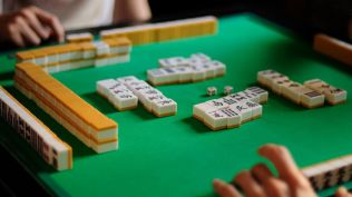 The game is played by four participants seated around a square table, each building a hand of 13 tiles drawn and discarded in turns. (Wikimedia Commons)