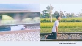After the train passes over him, the man stands unhurt and poses for the camera