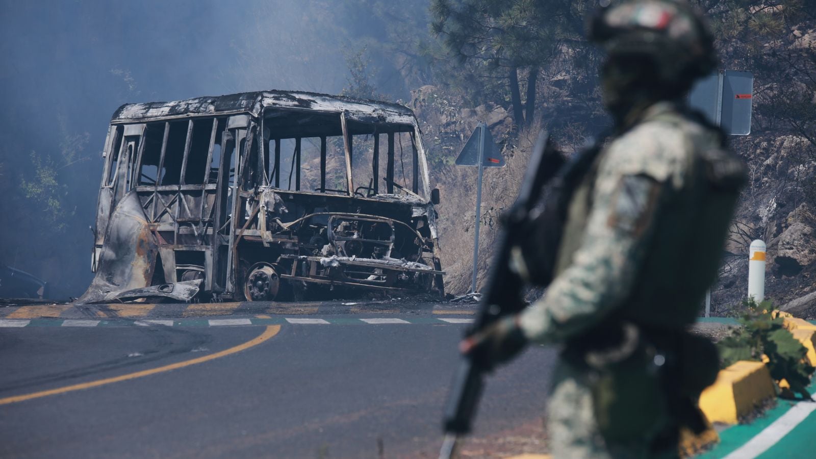 A soldier stands guard by a charred vehicle after it was set on fire, in Cointzio, Michoacán state, Mexico, Sunday, Feb. 22, 2026, after the death of the leader of the Jalisco New Generation Cartel, Nemesio Rubén Oseguera Cervantes, known as "El Mencho." (AP Photo)