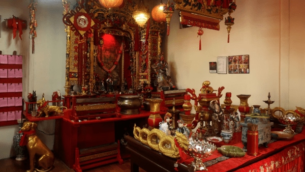 The main shrine inside the Chinese temple dedicated to Kwan Kung, the Chinese god of war, justice and wealth, adorned with red-and-gold altars, lanterns and ritual offerings.