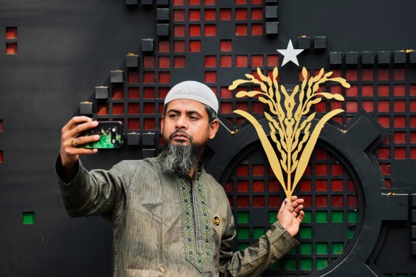 A Bangladesh Nationalist Party (BNP) supporter takes a selfie with the party symbol a day after the national parliamentary election, in Dhaka on February 13, 2026. 