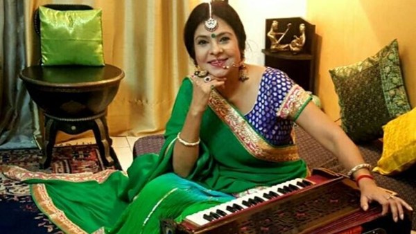 Malini Awasthi in a green saree sitting next to her instrument in a New Delhi home 