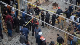 Pakistani security officials examine the site of of a bomb explosion at a Shiite mosque, in Islamabad, Pakistan.