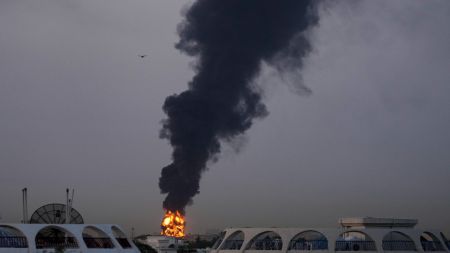 Dubai, Abu Dhabi News Live Updates: Fire and plumes of smoke rises after s drone struck a fuel tank forcing the temporary suspension of flights. near Dubai International Airport, in United Arab Emirates, early Monday, March 16, 2026. (AP Photo)