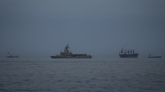 A UAE navy vessel patrols next to cargo ships and oil tankers in the Strait of Hormuz as seen from Khor Fakkan, United Arab Emirates.