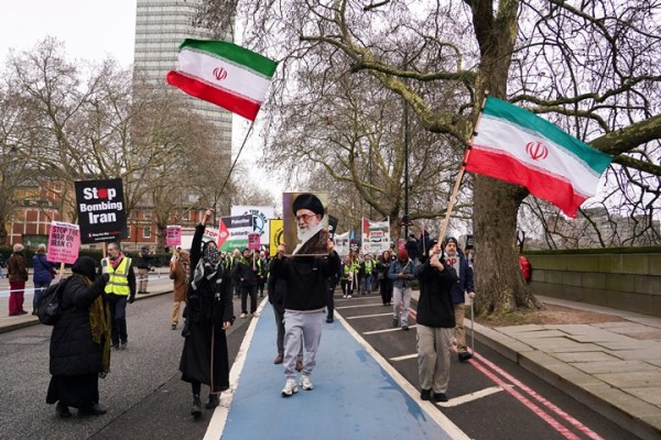 Demonstrators hold flags and a photograph of Iran's late Supreme leader Ayatollah Ali Khamenei as they attend a Stop the War Coalition march in London, Saturday, March 7, 2026. 