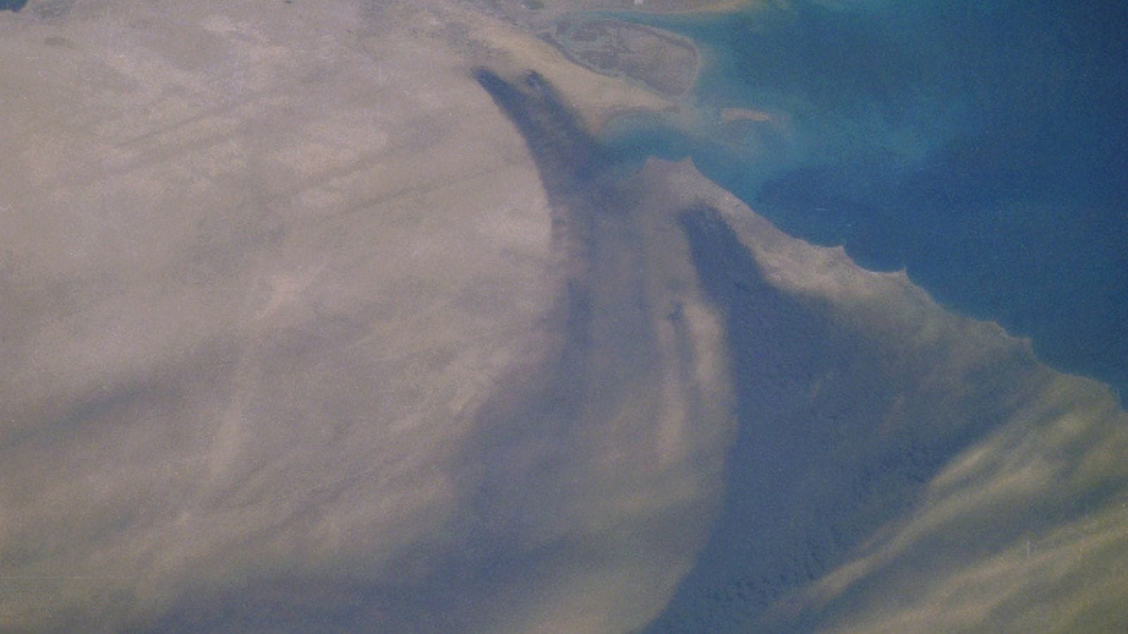 The Kuwait oil fields of Al Sabiriyah and Al Rawdatayn in the north (above centre) and the Al Burqan in the south (right of centre) burning and producing heavy black smoke (NASA)