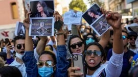 Women hold up drawings of Iranian Mahsa Amini as they shout slogans during a protest against her death, outside Iran's general consulate in Istanbul, Turkey, Wednesday, Sept. 21, 2022. (AP)