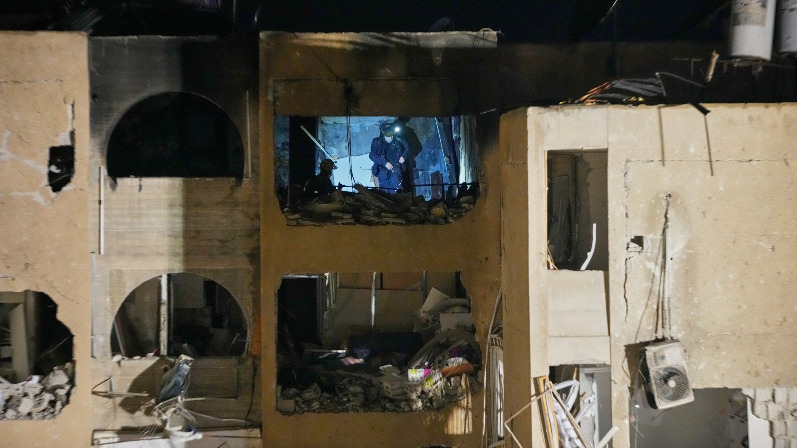 Israeli security forces and rescue teams work at the site struck by an Iranian missile in Arad, southern Israel (AP Photo)