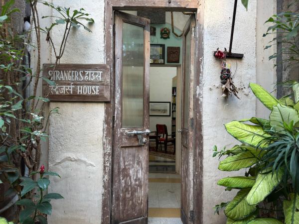 The entrance to Strangers House, marked by a modest wooden sign, opens into a space that feels more like a home than a gallery. (Express Photo) 