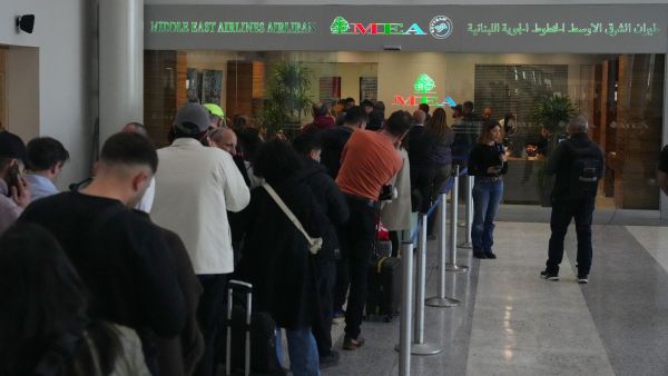 Passengers wait in front of the Middle East Airlines counter to rebook or buy new tickets at Beirut Rafik Hariri International Airport in Beirut, Lebanon. (AP Photo)