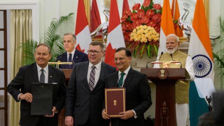 H.E. Premier Moe flanked by High Commissioner of India to Canada Dinesh Patnaik and Cameco CEO Tim Gitzel with PM’s Carney and Modi in the background (File photo)
