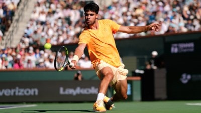 Carlos Alcaraz returns a shot against Daniil Medvedev during a semifinal match at the BNP Paribas Open tennis tournament, Saturday, March 14, 2026, in Indian Wells, Calif. (AP Photo)