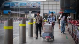 Passengers arrive at Dubai International Airport terminal as the airport resumes limited operations in Dubai (AP Photo)