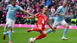 Bayern Munich's Harry Kane, center, and Berlin's Livan Burcu, left, challenge for the ball during a German Bundesliga soccer match. (Sven Hoppe/dpa via AP)