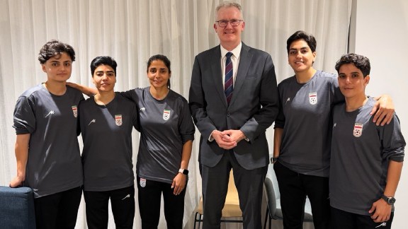 Australia's Minister for Home Affairs Tony Burke (center) poses with five Iranian women soccer players who have been granted asylum in Australia. (Australia Ministry of Home Affairs via AP)