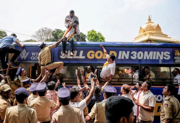 Police personnel detain Karnataka Rakshana Vedike members during a protest against the exclusion of Kannada in railway recruitment exams, at KSR Railway Station, in Bengaluru, March 17. (PTI Photo)