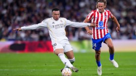 Real Madrid's Kylian Mbappe, left, and Atletico Madrid's Marcos Llorente challenge for the ball during the Spanish La Liga soccer match between Real Madrid and Atletico Madrid in Madrid, Spain, Sunday, March 22, 2026. (AP Photo)