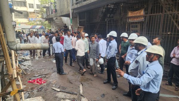 Officials taking stock of the fire that broke out in a four-storey factory at Bharatnagar, near Maruti Chowk in Kapodara. (Express Photo/Hanif Malek)